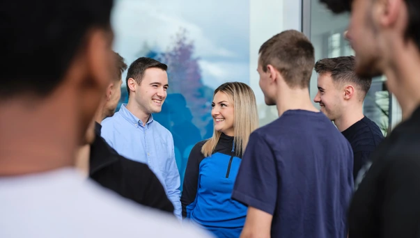 Group of people standing and talking outdoors.