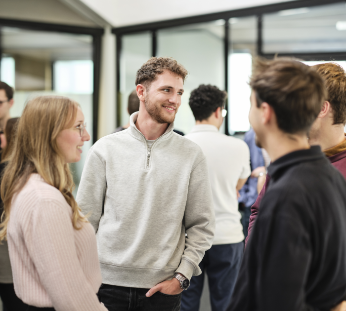 Group of people talking in modern office space.