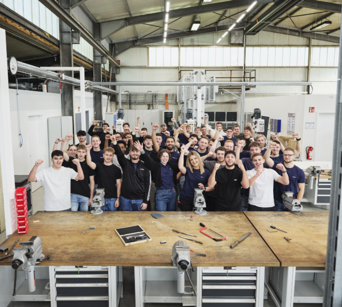 Team gathered in factory workspace setting.