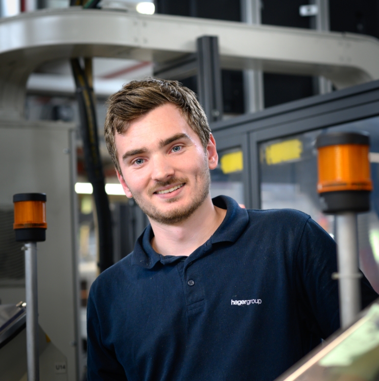 Smiling employee working with industrial machinery
