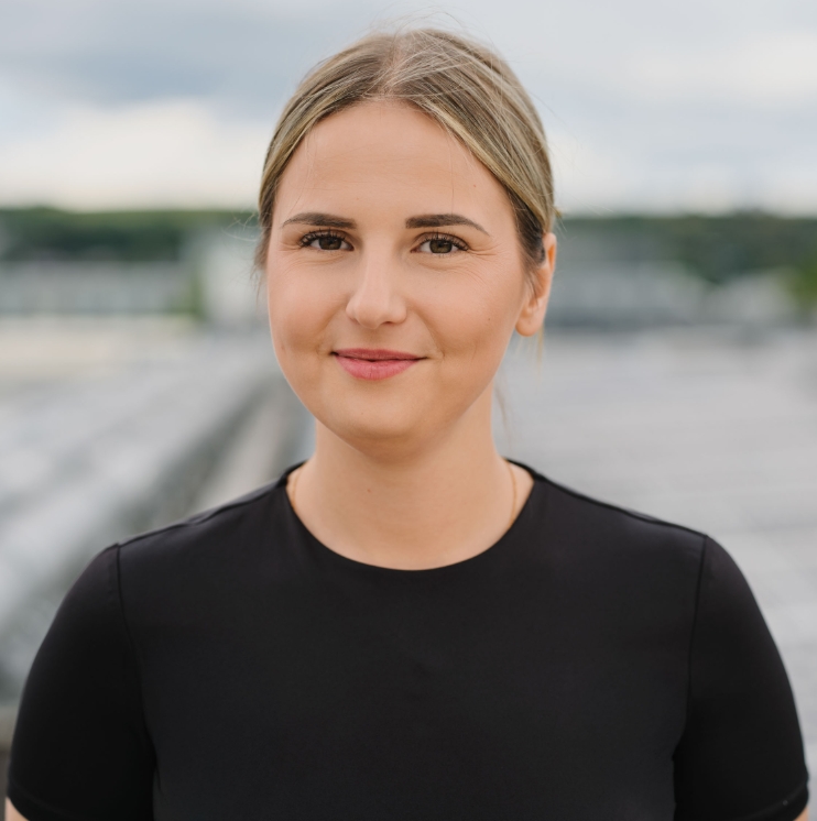 Professional woman smiling outdoors in business attire