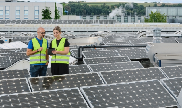 Workers inspecting rooftop solar panels