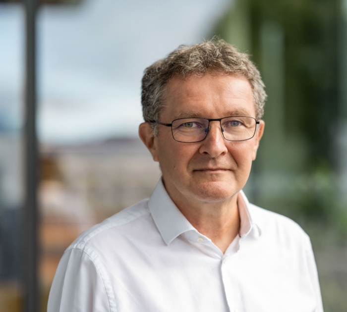 Smiling person wearing glasses in a professional portrait