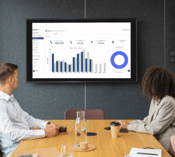 Team reviewing dashboard analytics on meeting room screen