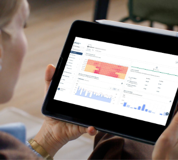 Person holding tablet showing analytics dashboard charts