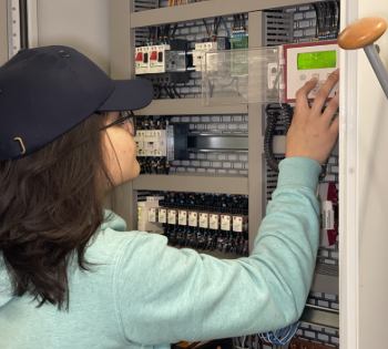 Technician adjusting control panel inside cabinet