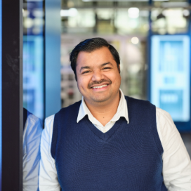 Smiling man in vest standing in modern office area