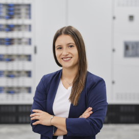 Confident woman smiling with arms crossed indoors