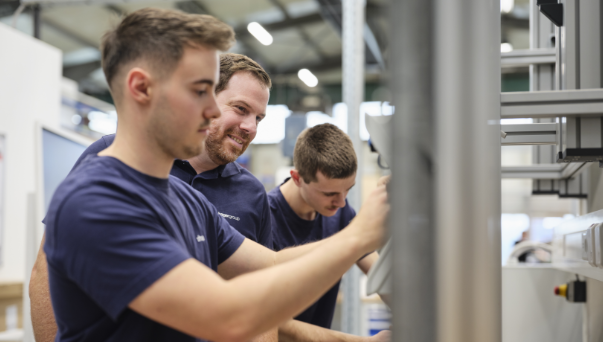 Team of technicians working together on industrial machine