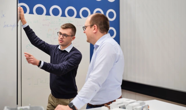 Zwei Kollegen besprechen Ideen am Whiteboard