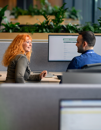 Twee mensen werken samen aan computerschermen