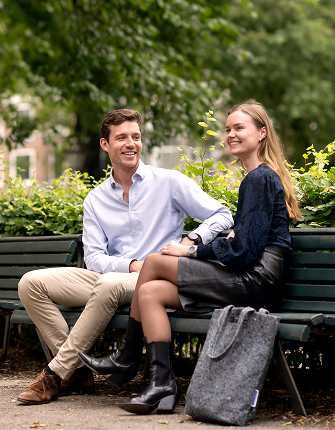 Koppel zit lachend samen op bank in park