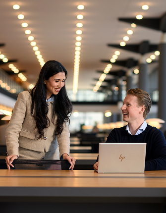 Twee collega’s werken samen met laptop op kantoor