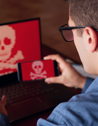 Laptop met rood scherm en schedel-icoon