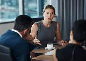 Zakenvrouw in gesprek aan tafel met koffie