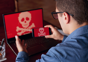 Laptop met rood scherm en schedel-icoon