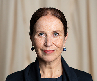 Woman with brown hair in blue earrings and dark clothing