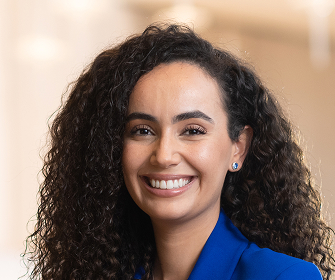 Woman with curly dark hair in blue blazer