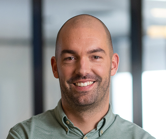 Man with shaved head in light green shirt