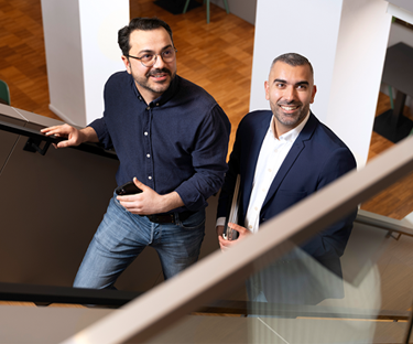 Twee personen lopen een trap op in een kantooromgeving.