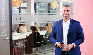 Persoon in een modern kantoor met blauwe financiële iconen eromheen.