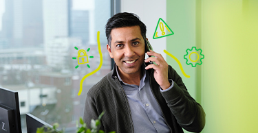 Persoon in een kantoorruimte die telefoneert, met groene IT‑gerelateerde iconen eromheen.