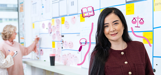 Persoon voor een bord met planningsoverzichten en roze juridische iconen eromheen.