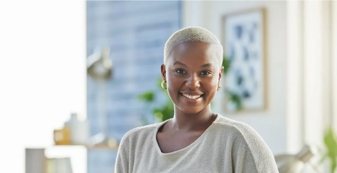 Woman in beige jumper smiling at camera