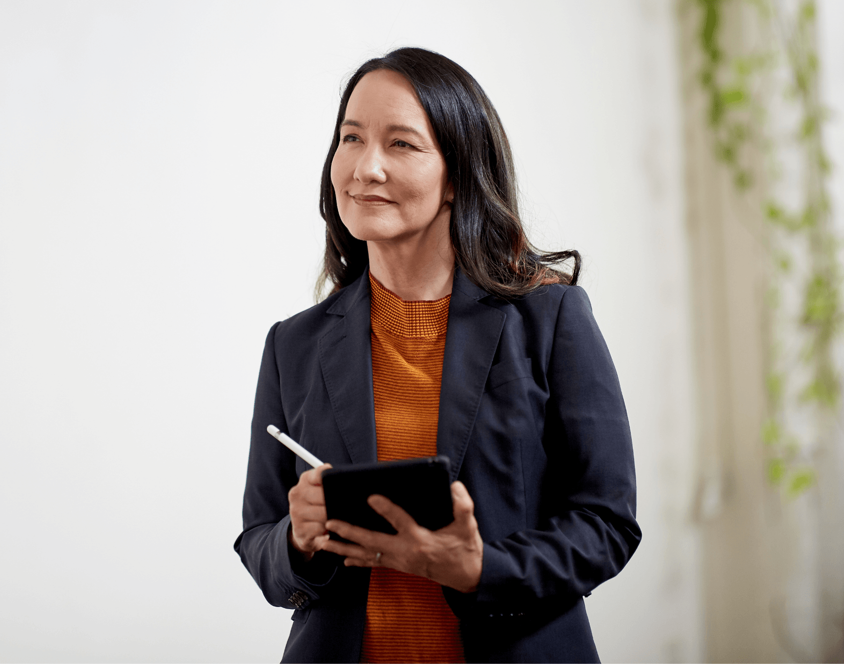 A professional in a modern office holding a notebook.