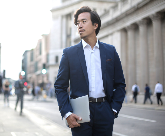 A professional standing outdoors, looking ahead.