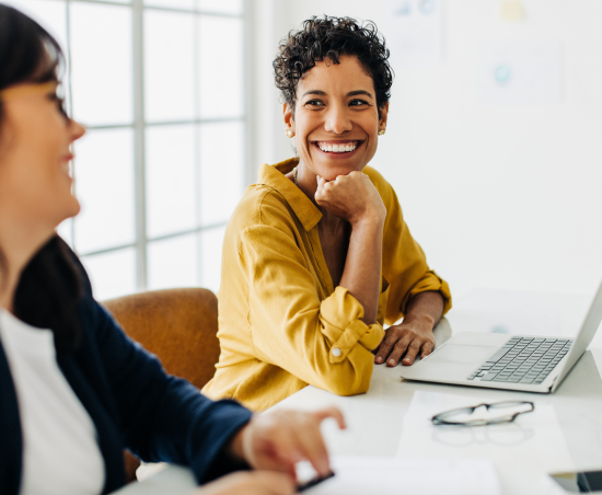 Two colleagues engaged in a conversation in an office environment.
