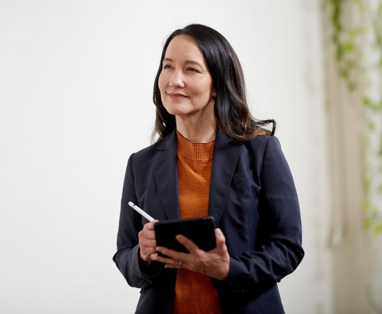 A professional in a modern office holding a notebook.