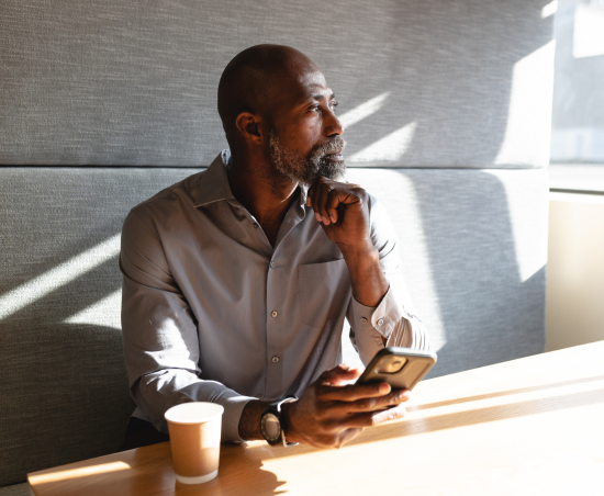 A professional sat at a desk, looking out of the office window.