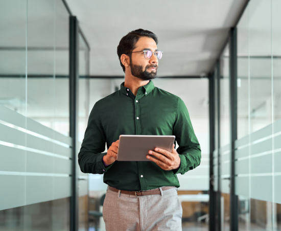 A professional in a modern office holding a notebook.