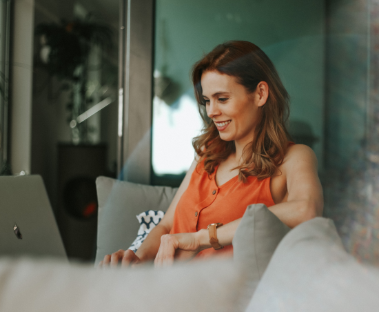 A professional smiling while seated in an office environment.