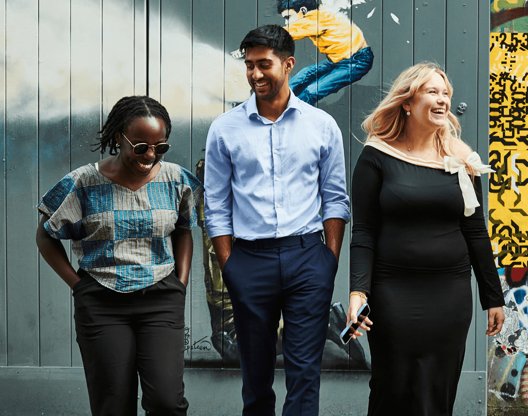 A group of colleagues laughing together outside of the office.