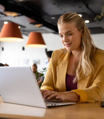 A professional smiling while seated at a work desk.