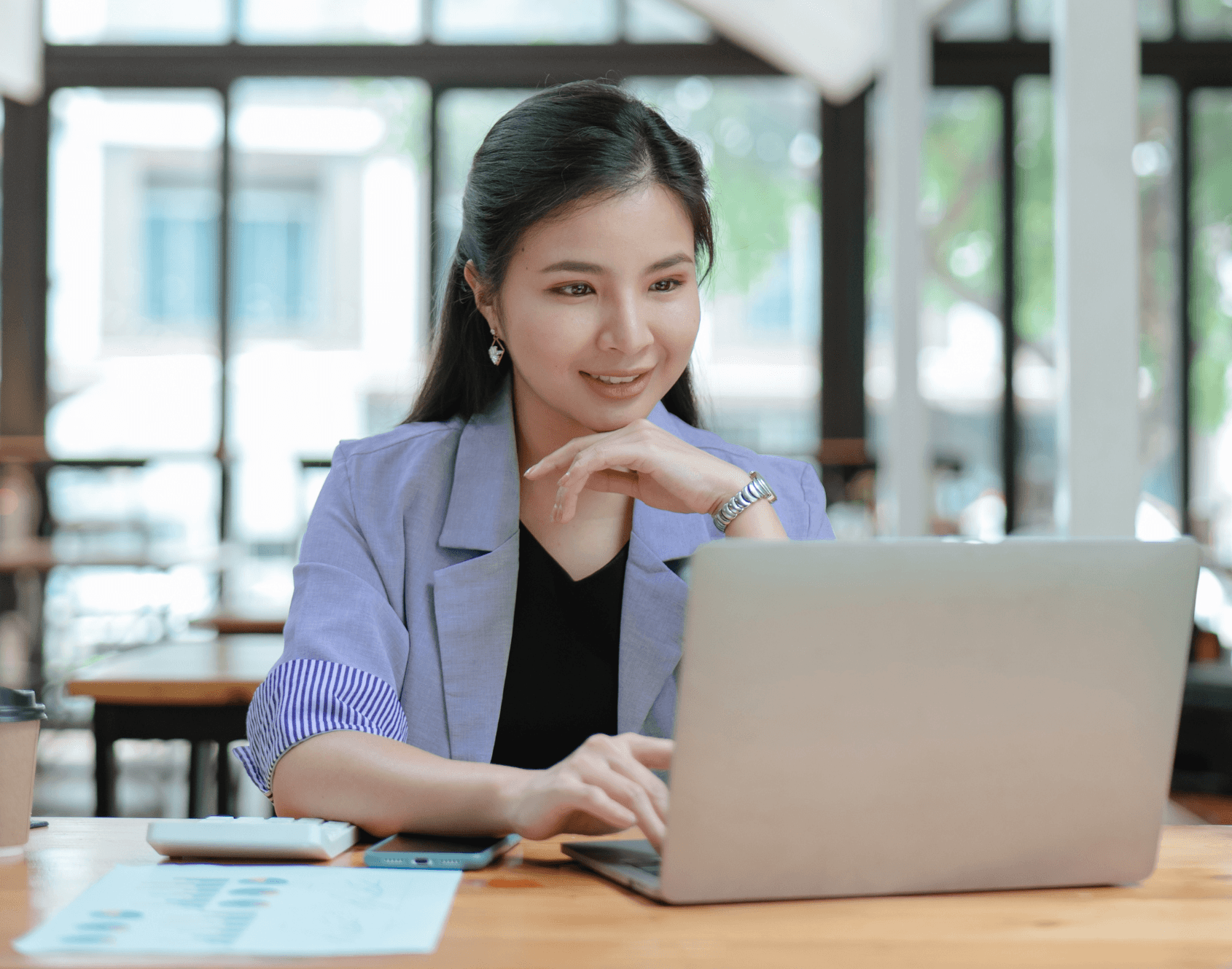 A professional smiling while seated in an office environment.