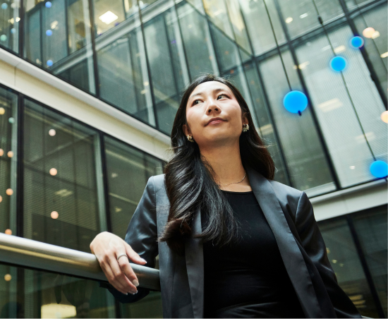 A professional walking outside of the office, looking towards the sky.