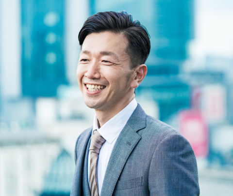 A professional smiling outside of the office.