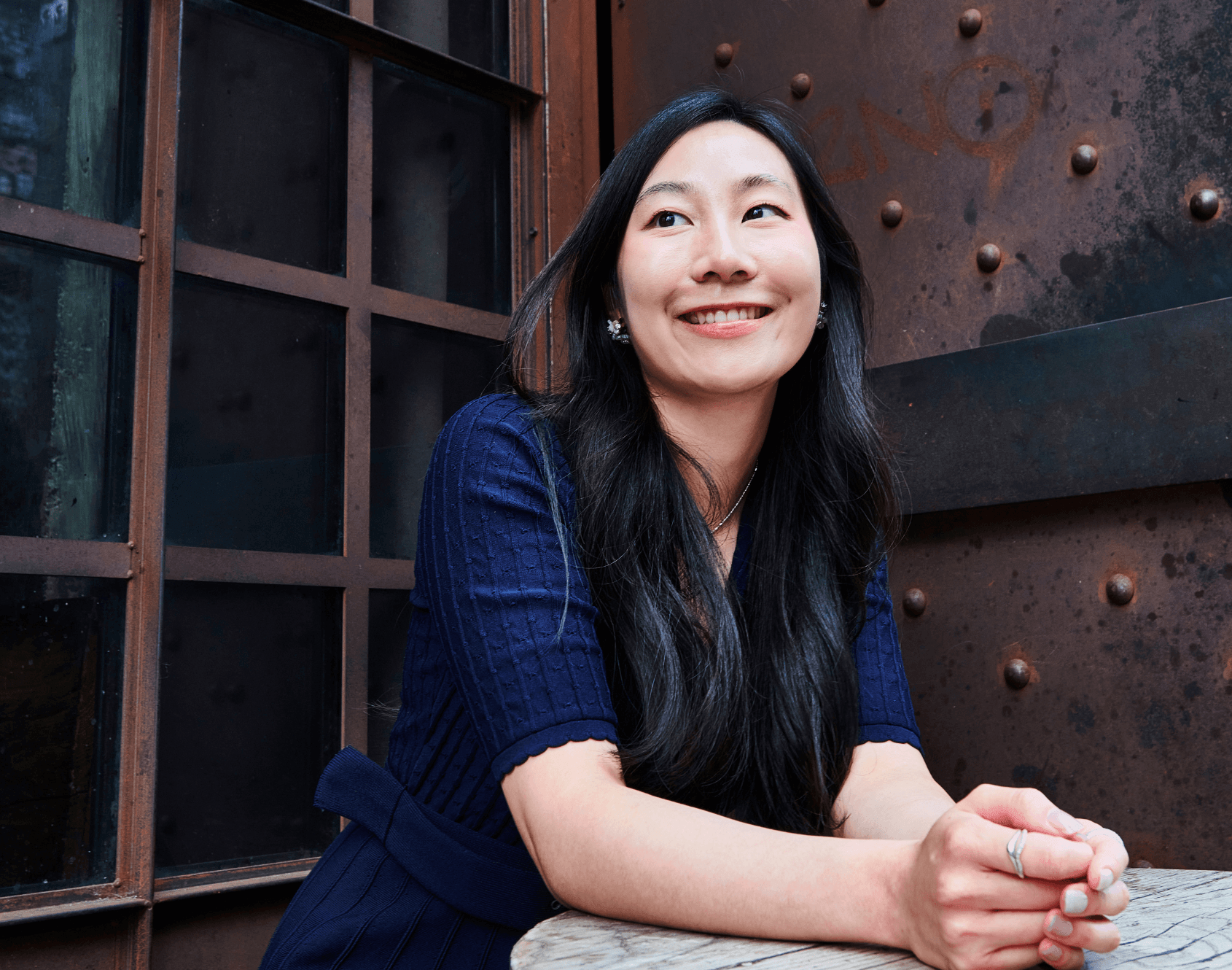 A professional smiling while seated in an office environment.