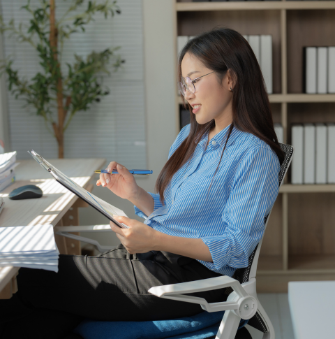 A professional in a modern office holding a notebook.