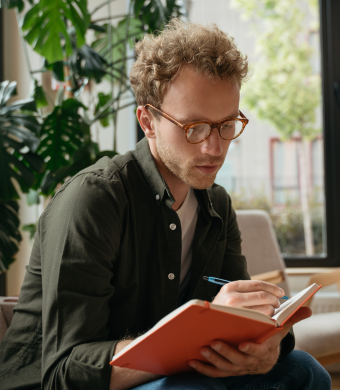 A professional in a modern office holding a book.