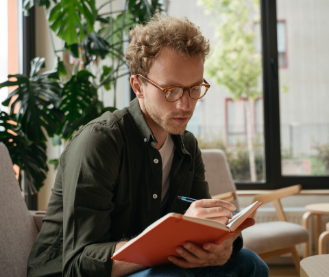 A professional in a modern office holding a notebook.