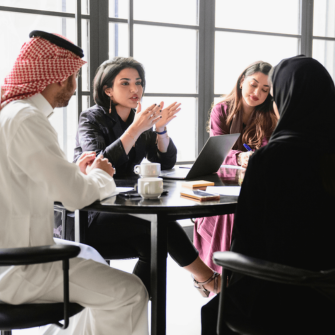 A group of professionals in a workplace setting, reflecting a collaborative work environment.