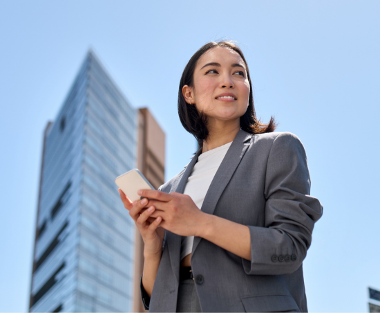A professional standing outside of the office, looking up.