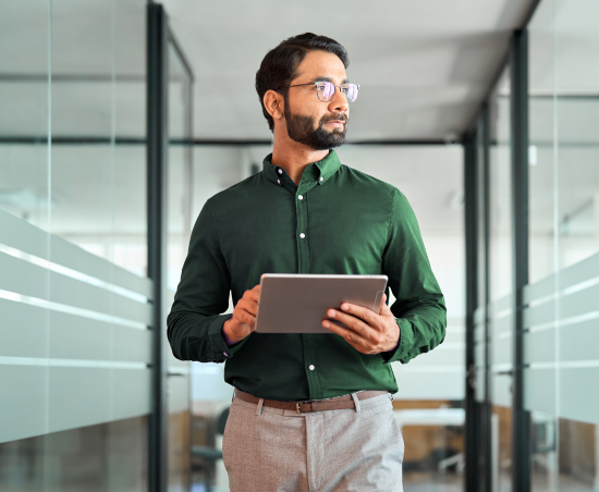 A professional in a modern office holding a notebook.