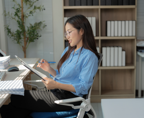A professional smiling while seated at a work desk.