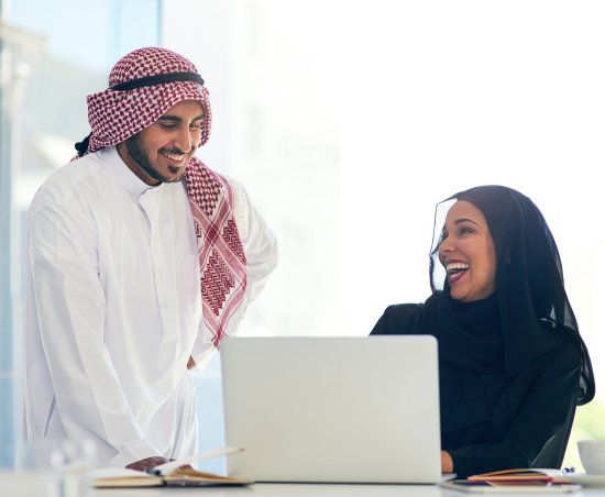 Two colleagues engaged in conversation while seated in an office environment.