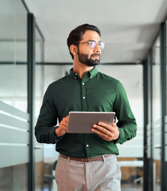 A professional in a modern office holding a notebook.